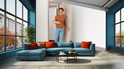 portrait of man walking in apartment with pizza boxes Wall mural