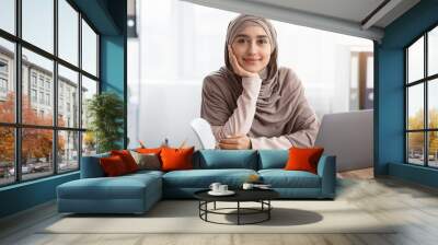 Portrait of muslim female entrepreneur sitting at workplace in modern office Wall mural