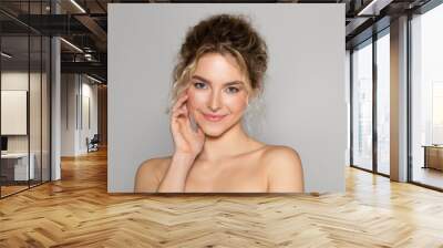 Portrait of sensual beautiful young woman posing on grey studio background, enjoying her smooth glow face skin Wall mural