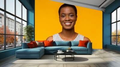 Portrait of smiling black woman on yellow background Wall mural