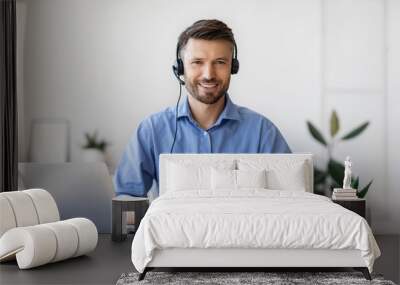 Portrait of smiling male customer service operator in headset at workplace Wall mural