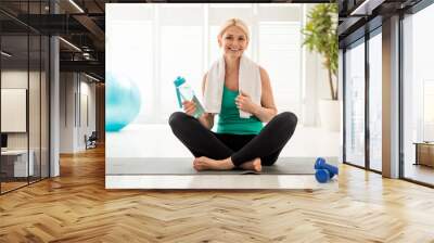 Portrait Of Smiling Senior Woman In Activewear Posing On Yoga Mat At Home Wall mural