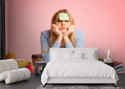 Portrait of tired teenage girl sitting at her desk Wall mural