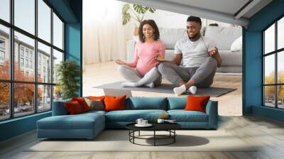 Positive black expecting couple having online yoga class Wall mural