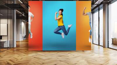 Positive multiracial people jumping in air and celebrating success, exclaiming with joy over bright neon backgrounds Wall mural