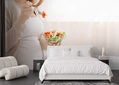 Pregnant woman eating fresh vegetable salad in bed Wall mural