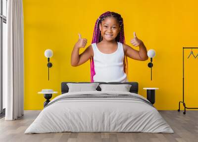 Pretty little african american girl gesturing thumbs up and smiling Wall mural