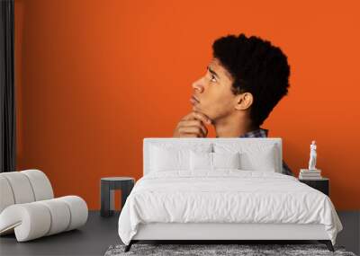 Problem solution. African-American man deep in thought on color background, side view. Blank space Wall mural