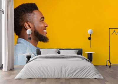 profile portrait of cheerful bearded black guy on yellow background Wall mural