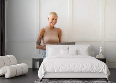 Remote work. Portrait of happy lady with laptop computer sitting on floor over white wall, empty space Wall mural