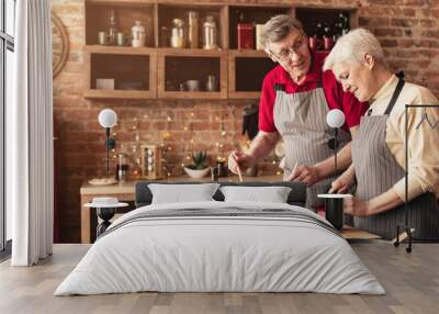 Retired couple preparing healthy lunch at kitchen Wall mural