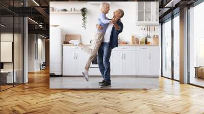 Romantic elderly man and woman dancing at kitchen Wall mural