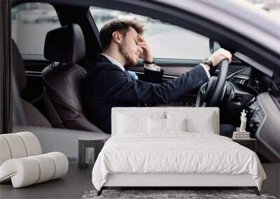 Sad businessman driving alone in his new car Wall mural