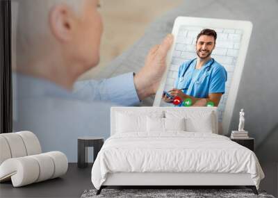 Senior woman using digital tablet at home having online consultation with doctor Wall mural