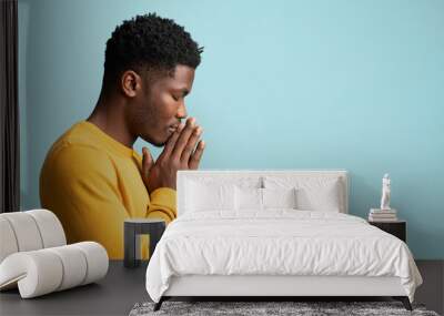 Side view of praying african american young man, copy space Wall mural