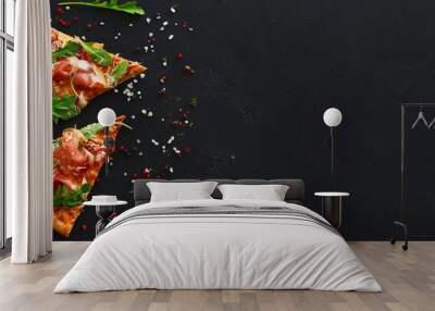 Slices of pizza with spices on black background Wall mural