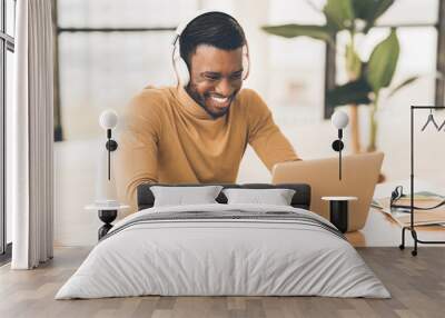 Smiling african american businessman chatting online at work Wall mural