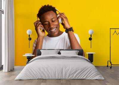 Smiling african man listening to music in headphones Wall mural