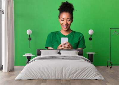 Smiling afro girl using cell phone at studio Wall mural