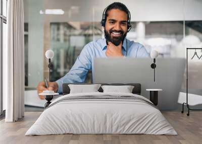 Smiling bearded young guy employee have online conference Wall mural