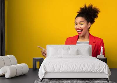 Smiling black girl pointing two fingers at free space Wall mural