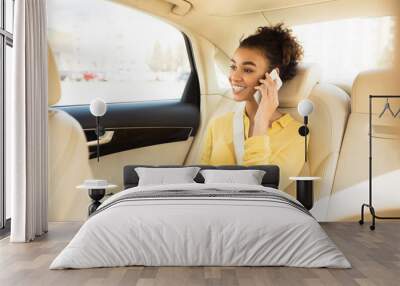 Smiling Black Woman Talking On Phone Sitting In Taxi Cab Wall mural