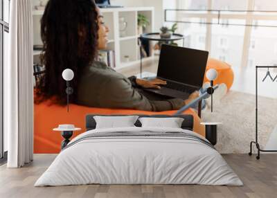 Smiling black woman using laptop at home, mockup Wall mural