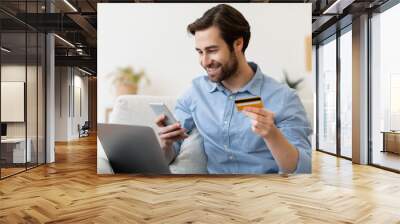 Smiling Guy With Phone And Credit Card Shopping Online Indoor Wall mural