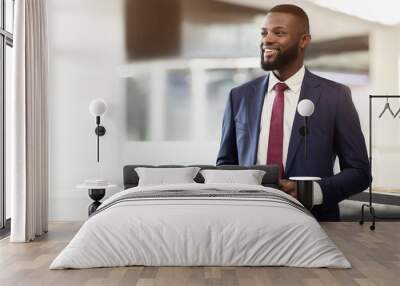 Smiling handsome confident african american millennial businessman ceo with beard use tablet, look at free space Wall mural