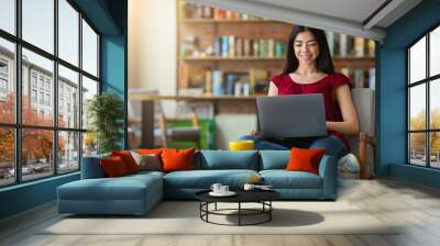 Smiling korean girl using laptop for online work or studies at cafe Wall mural