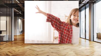 Smiling little girl raising hands up, having fun Wall mural