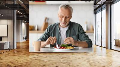 Smiling Senior Man Eating Tasty Breakfast Or Lunch In Kitchen At Home Wall mural