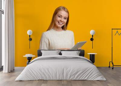 Smiling teenage girl holding digital tablet and looking to camera Wall mural