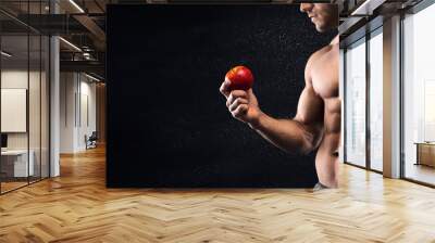 Sporty young man with beautiful torso holding fresh red apple Wall mural