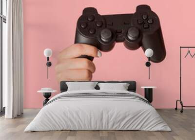 Stay home activities. Female hand showing video game console on pink background, closeup Wall mural