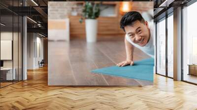 Strong asian mature man making strength workout Wall mural