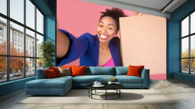 Stylish afro woman making selfie with shopping bag Wall mural