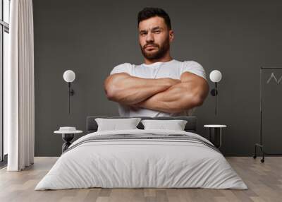 Suspicious young man with crossed big muscular arms Wall mural