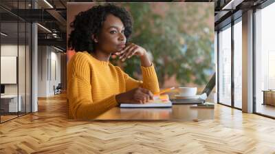 Thoughtful afro woman looking for new job online Wall mural