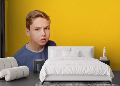 Thoughtful dissatisfied curious teen boy closeup portrait, orange studio background Wall mural