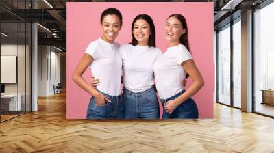 Three Women Embracing Standing In Studio On Pink Background, Panorama Wall mural