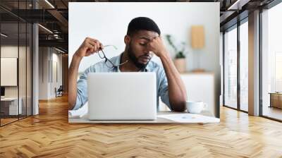 tired african american employee having headache after working on laptop Wall mural