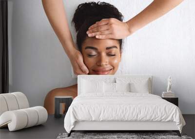 Top view of smiling black lady getting face massage Wall mural