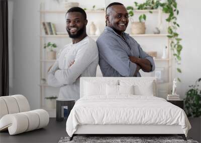 Two Generations. Happy Black Man Standing Back To Back With Senior Father Wall mural