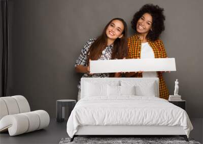 Two girlfriends holding blank white banner Wall mural