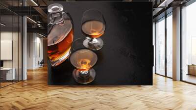 Two glasses of brandy or cognac and bottle on black Wall mural