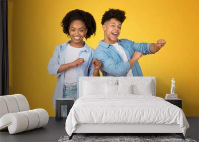 Two joyful African American teenagers dancing, with the young woman in a light blue shirt Wall mural