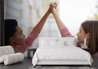 Two women raising hands up, fighting for women rights Wall mural