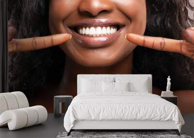 Unrecognizable black woman pointing at her healthy white teeth, closeup Wall mural