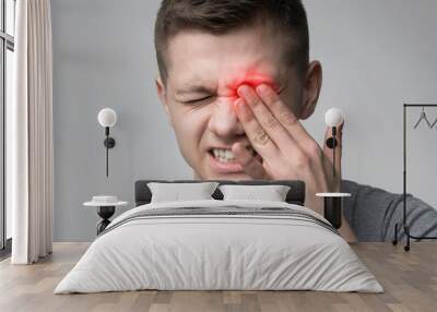 Upset man suffering from strong eye pain Wall mural